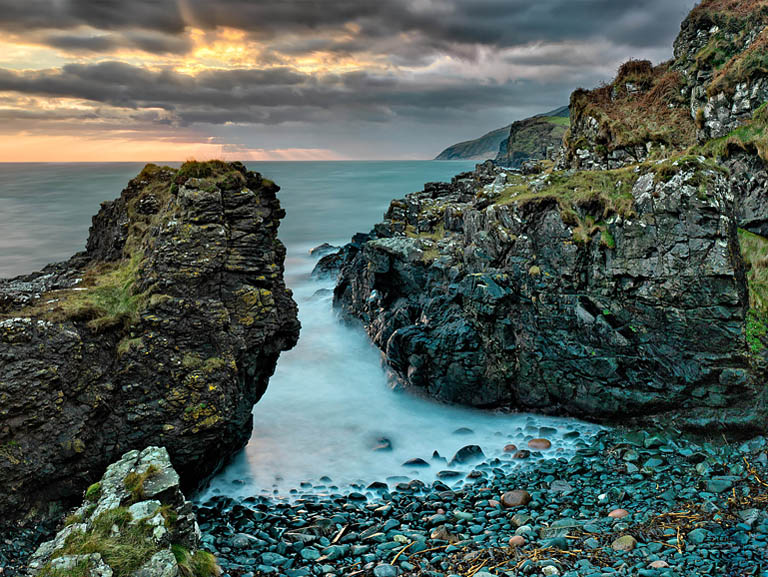 Fine art seascape photograph of Portaleen Bay in County Antrim at sunrise.