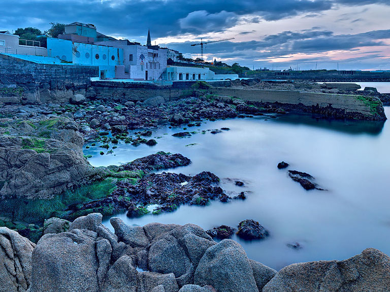 View of Dun Laoghaire Baths and promenade with calm sea and soft evening light over Dublin Bay