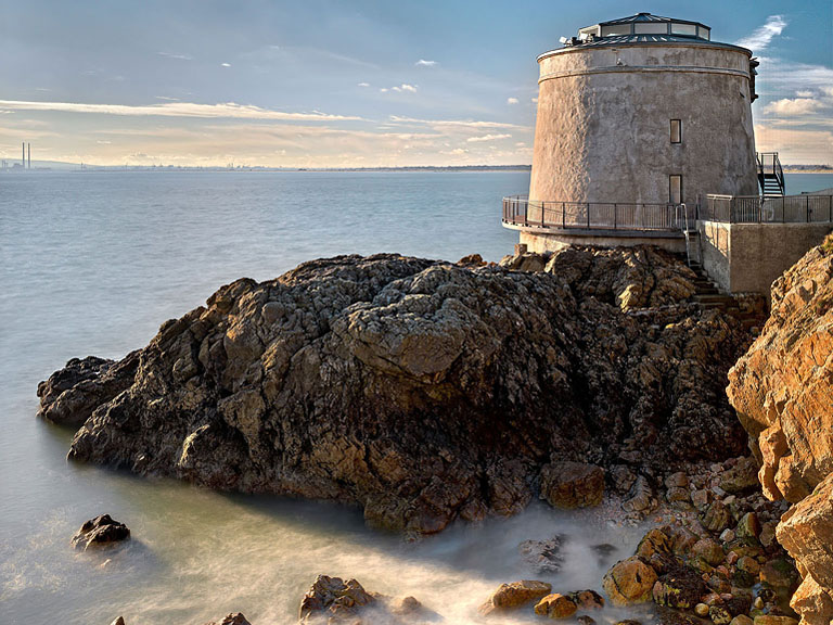 Photograph of sunlit rocks and tide pools below the Martello tower at Sutton on Dublin Bay.