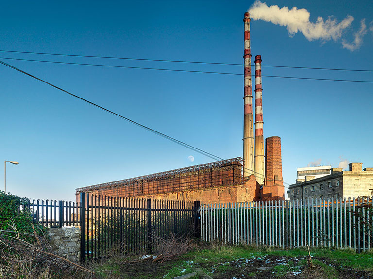 Fine art photograph of Poolbeg Power Station seen from the Pigeon House in Ringsend, with chimneys, water and industrial foreground at night.