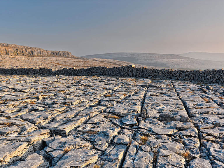 Fine art photograph of a stone wall crossing the limestone pavement above Black Head in the Burren, County Clare