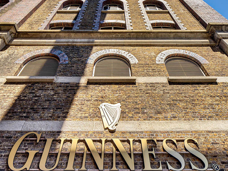 Corner view of the Guinness Storehouse on Market Street in Dublin showing brick walls windows and sky.