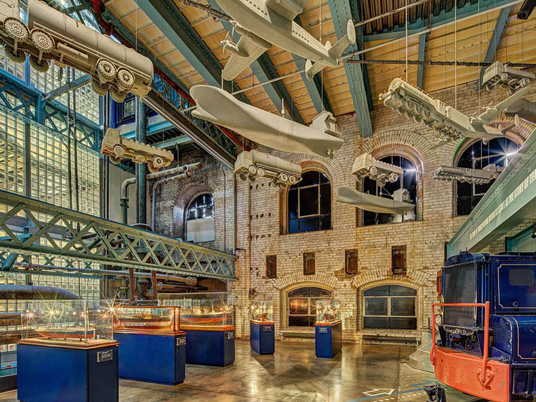 Architectural models displayed inside the Guinness Storehouse in Dublin framed by steel structure glass and reflections.
