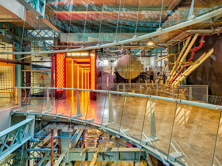 Interior photograph of the atrium and walkways inside the Guinness Storehouse in Dublin with glass floors and steel beams.