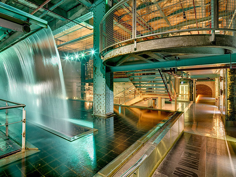 Close up photograph of the waterfall inside the Guinness Storehouse in Dublin showing textured cascading water and surrounding structure.