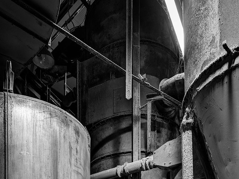 Industrial interior photograph of an animal feed plant with steel structures and conveyors