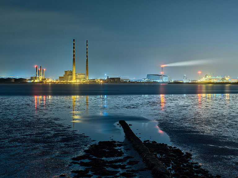 Bull Wall on Dollymount Strand in Dublin Bay at low tide at night, exposed seabed lit by city lights