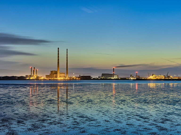 Bull Island shoreline at dusk with calm water and distant view towards Dublin Port, fine art seascape