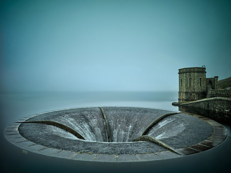 Overflow structure at Silent Valley Reservoir in County Down with still water, surrounding slopes and mist