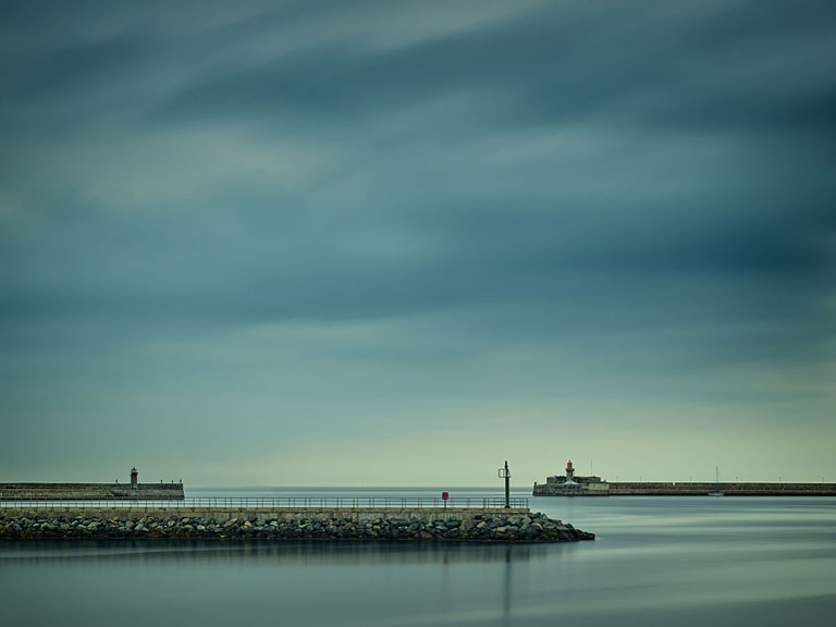 Dun Laoghaire Harbour in Dublin Bay with still water, moored boats and harbour walls, calm seascape photograph