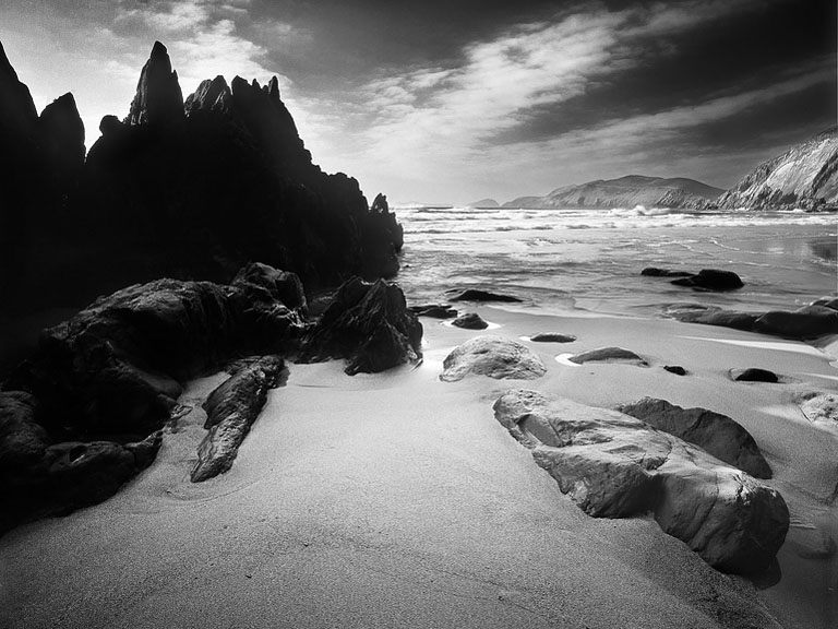 Black and white seascape of waves and cliffs at Coumeenole Beach on the Dingle Peninsula