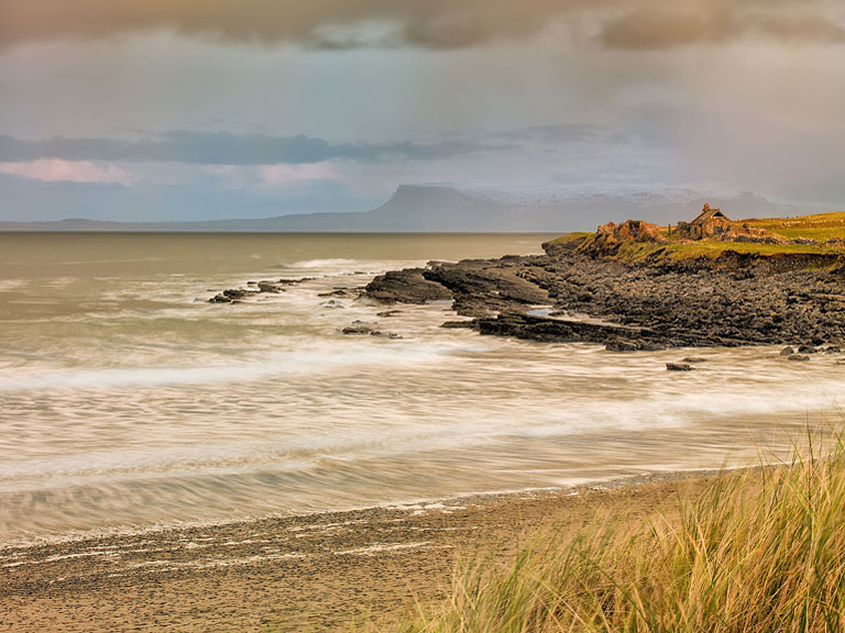 Fine art photograph of the curving shoreline and emerald green sea at Dunmoran Beach in County Sligo