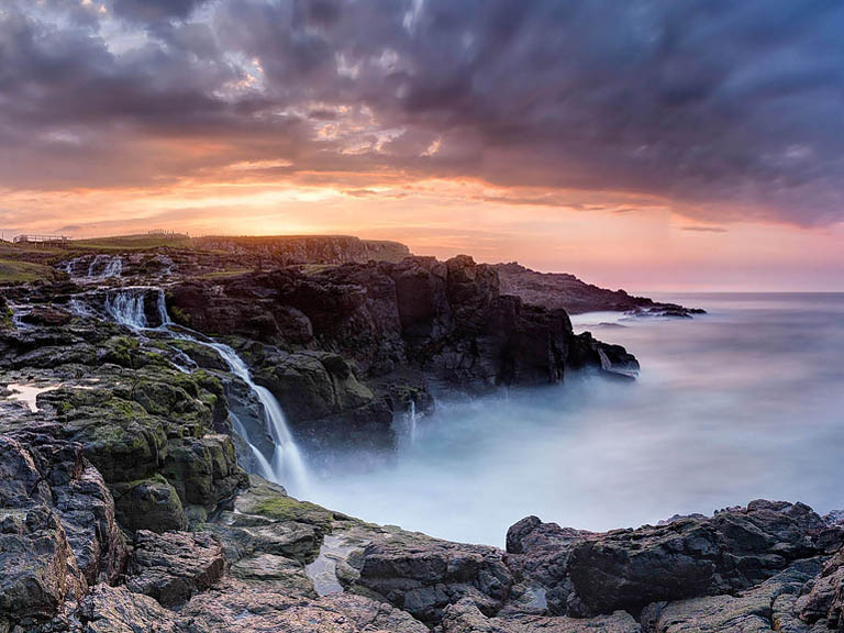 Fine art photograph of Dunsverick Waterfall at sunset on the County Antrim coast