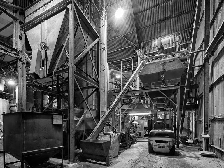 Complex industrial interior of an animal feed plant with chutes, platforms and structural steel.