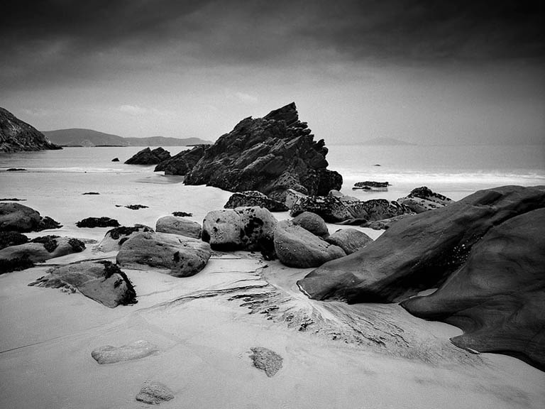 Breaking waves and layered surf patterns at Keem Strand on Achill Island, forming a calm seascape.