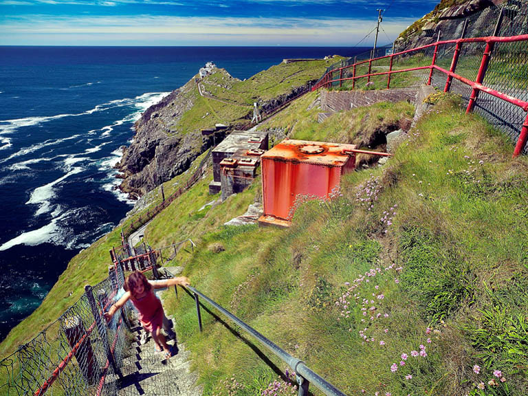 Landscape photograph of the cliffs at Mizen Head in County Cork with two children walking along the path above the Atlantic