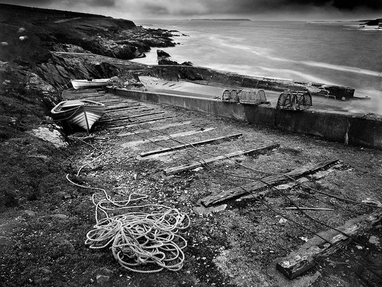 Fine art photograph of an old stone quay on the Donegal coast, with calm water and distant headlands under a soft sky